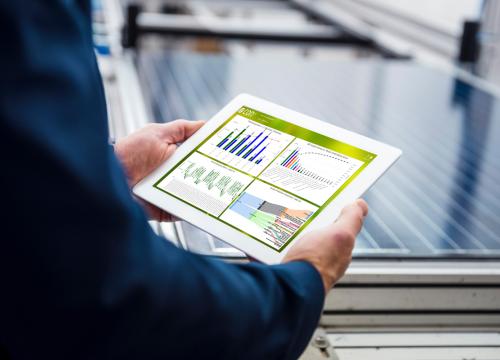 zwei Händel halten Tablet mit Energiemonitoring-Tool